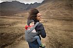 Mother carrying son in sling, Fairy Pools, near Glenbrittle, Isle of Skye, Hebrides, Scotland