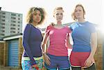 Portrait of three women standing together wearing sports clothing