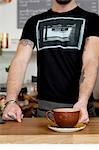 Cropped shot of cafe waiter serving cup of fresh coffee