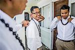 Three young men preparing for Hawaiian wedding wearing kukui nut beads, Kaaawa, Oahu, Hawaii, USA