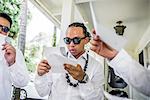 Young men preparing for Hawaiian wedding wearing kukui nut beads, Kaaawa, Oahu, Hawaii, USA