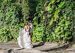 Bride and bridegroom strolling in garden at Hawaiian wedding, Kaaawa, Oahu, Hawaii, USA