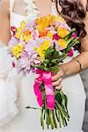 Cropped view of bride and colorful boquet at Hawaiian wedding, Kaaawa, Oahu, Hawaii, USA