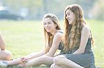 Teenage girls sitting in park chatting