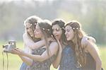 Four teenage girls in park  taking instant camera selfie