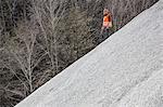 Quarry worker moving down gravel mound at quarry