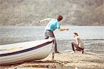 Young man and girlfriend skimming stones in Lake Mergozzo, Verbania, Piemonte, Italy