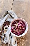 Small bowl of red cabbage salad with sesame on wooden table