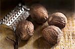 Nutmegs and a nutmeg grater on a wooden surface