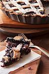 Freshly baked mulberry pie with a lattice crust and icing sugar, sliced