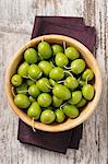 Fresh green olives in a wooden bowl