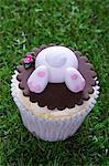 An Easter bunny cupcake on a grass surface