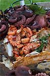 Fried fish, prawns and octopus in a bowl in a garden