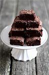 A stack of brownies on a cake stand