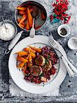 Braised pork on a bed of red cabbage with carrots (seen from above)