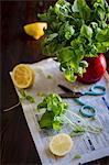 A large bunch of basil in a vase on a piece of newspaper