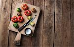 Various tomatoes on a chopping board with salt and a knife