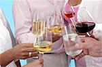People raising glasses of various different drinks