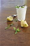 Lemon granita, lemons and fresh mint on a wooden surface