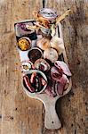 A ploughman's lunch platter of ham, sausages, Scotch eggs, chutney, pickle and bread rolls (England)