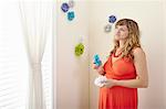 Pregnant woman decorating nursery with paper flowers