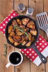 Spiced baked potatoes with rosemary in a cast iron pan