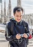 Young man standing on roof of Duomo Cathedral, Milan, Italy