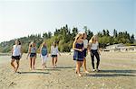 Family of sisters and female cousins strolling on beach