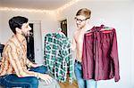 Male couple, mid adult man asking for help choosing shirt