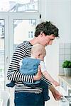 Father tending baby in kitchen