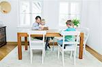 Mother and two children with digital tablet in living room