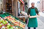 Man with crate in front of greengrocer's shop