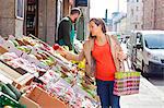 Woman choosing fruit in greengrocer's shop