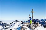 Ski holiday, Man cheering on mountain peak, Sudelfeld, Bavaria, Germany