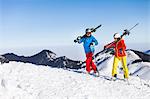 Ski holiday, Couple hiking with skis on shoulders, Sudelfeld, Bavaria, Germany