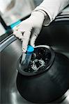 Scientist inserting test tube into centrifuge