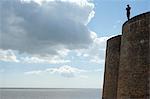 Antony Gormley's sculpture of a man looking out to sea, standing on the Napoleonic Martello tower in Aldeburgh, Suffolk, England, United Kingdom, Europe