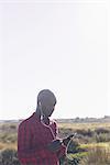 Man using smartphone and earphones outdoors