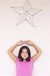 Girl standing beneath star decoration, daydreaming, portrait