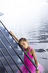 Little girl in ballerina costume leaning against staircase railing