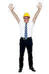 Contemporary construction engineer celebrating success by throwing his hands up in the air.