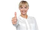 Blonde woman in formal attire showing thumbs up gesture, business concept.