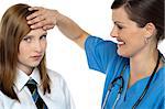 Doctor placing her hand on a patients forehead. Symptoms of fever.