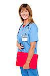 Side profile of a cheerful middle aged nurse posing with clipboard in hand.