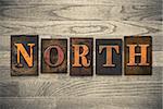 The word "NORTH" theme written in vintage, ink stained, wooden letterpress type on a wood grained background.
