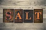 The word "SALT" theme written in vintage, ink stained, wooden letterpress type on a wood grained background.