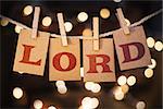 The word LORD spelled out on clothespin clipped cards in front of glowing lights.