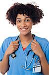 Smiling curly haired lady doctor with stethoscope around her neck.