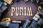 The word PURIM written in rusted metal letters surrounded by vintage wooden and metal letterpress type.