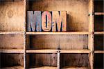 The word MOM written in vintage wooden letterpress type in a wooden type drawer.